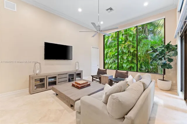 a living room with furniture a flat screen tv and a large window