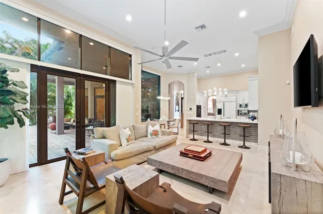 a living room with furniture a flat screen tv and a floor to ceiling window