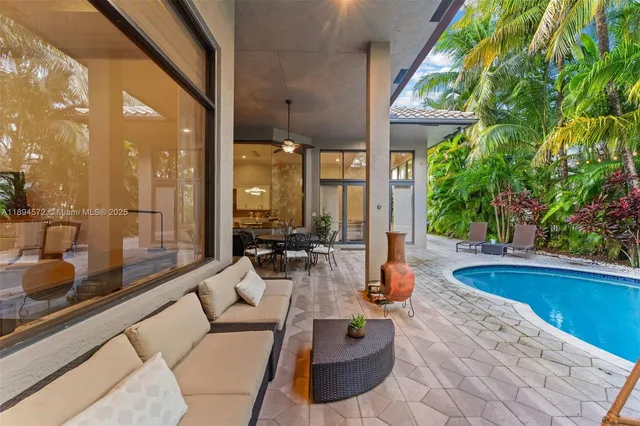 a living room with patio furniture and a potted plant