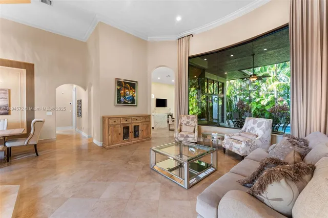 a living room with furniture a fireplace and floor to ceiling windows