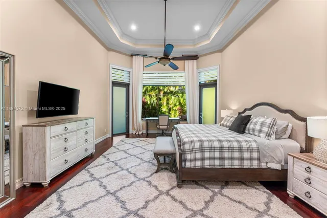 a bedroom with a large bed and a flat tv screen on dresser