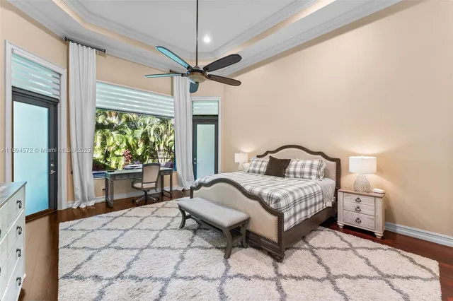 a spacious bedroom with a bed a chandelier and a large window