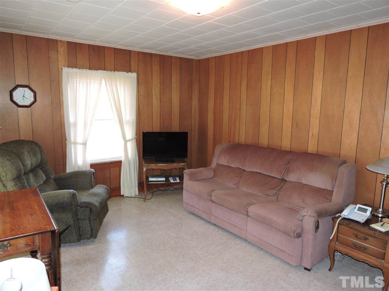 8320 Bacon Road Timberlake, NC 27583 - Photo 18 of 21 a living room with furniture a flat screen tv and a window