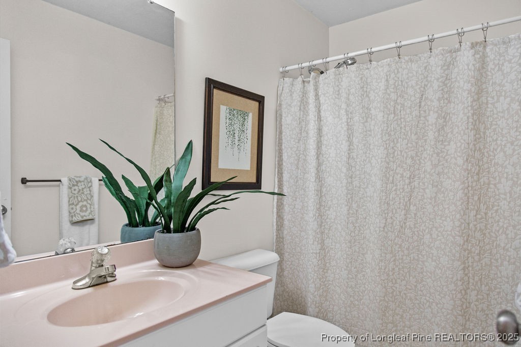 330 Fox Run Road Pinehurst, NC 28374 - Photo 16 of 31 a bathroom with a sink a mirror and a toilet