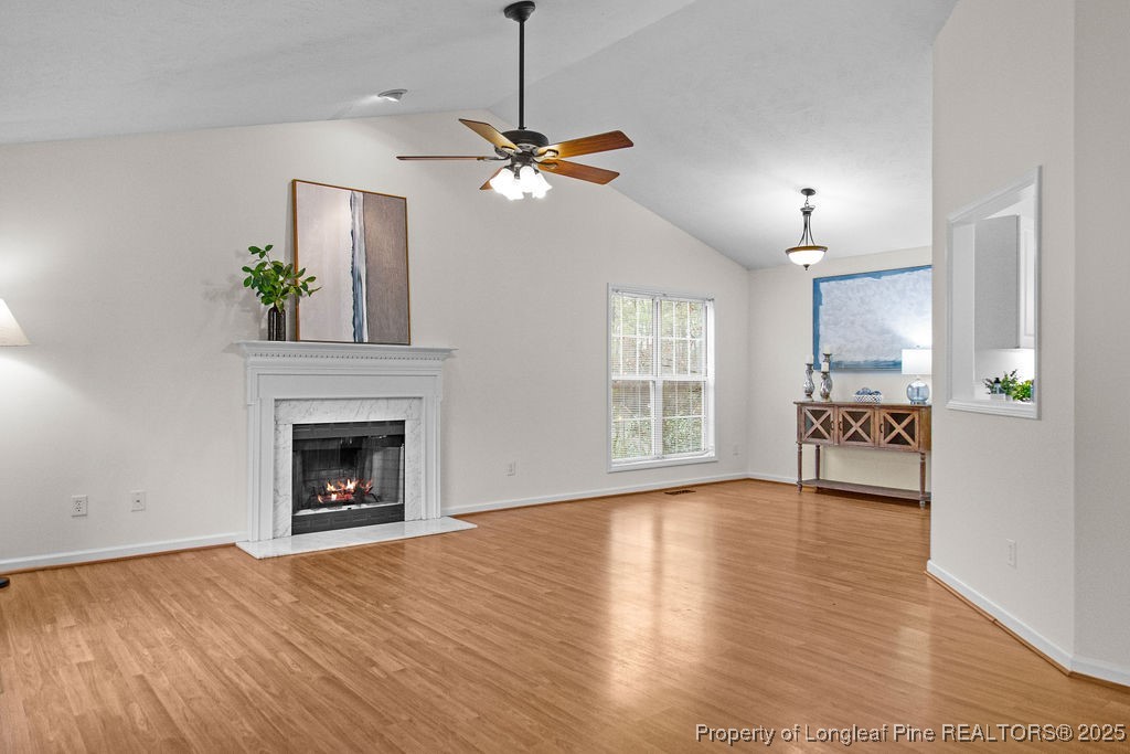 330 Fox Run Road Pinehurst, NC 28374 - Photo 5 of 31 a view of a livingroom with a fireplace a ceiling fan and windows
