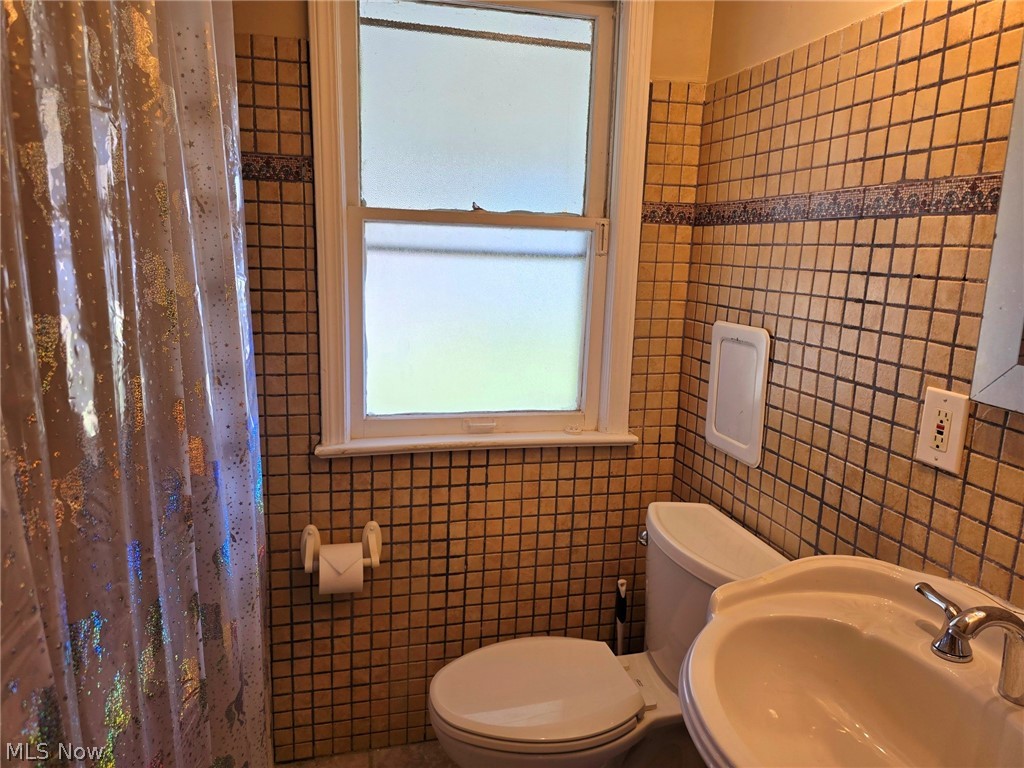 4111 Redfern Road Parma, OH 44134 - Photo 14 of 40 First floor bathroom featuring tile walls, pedestal sink, and toilet