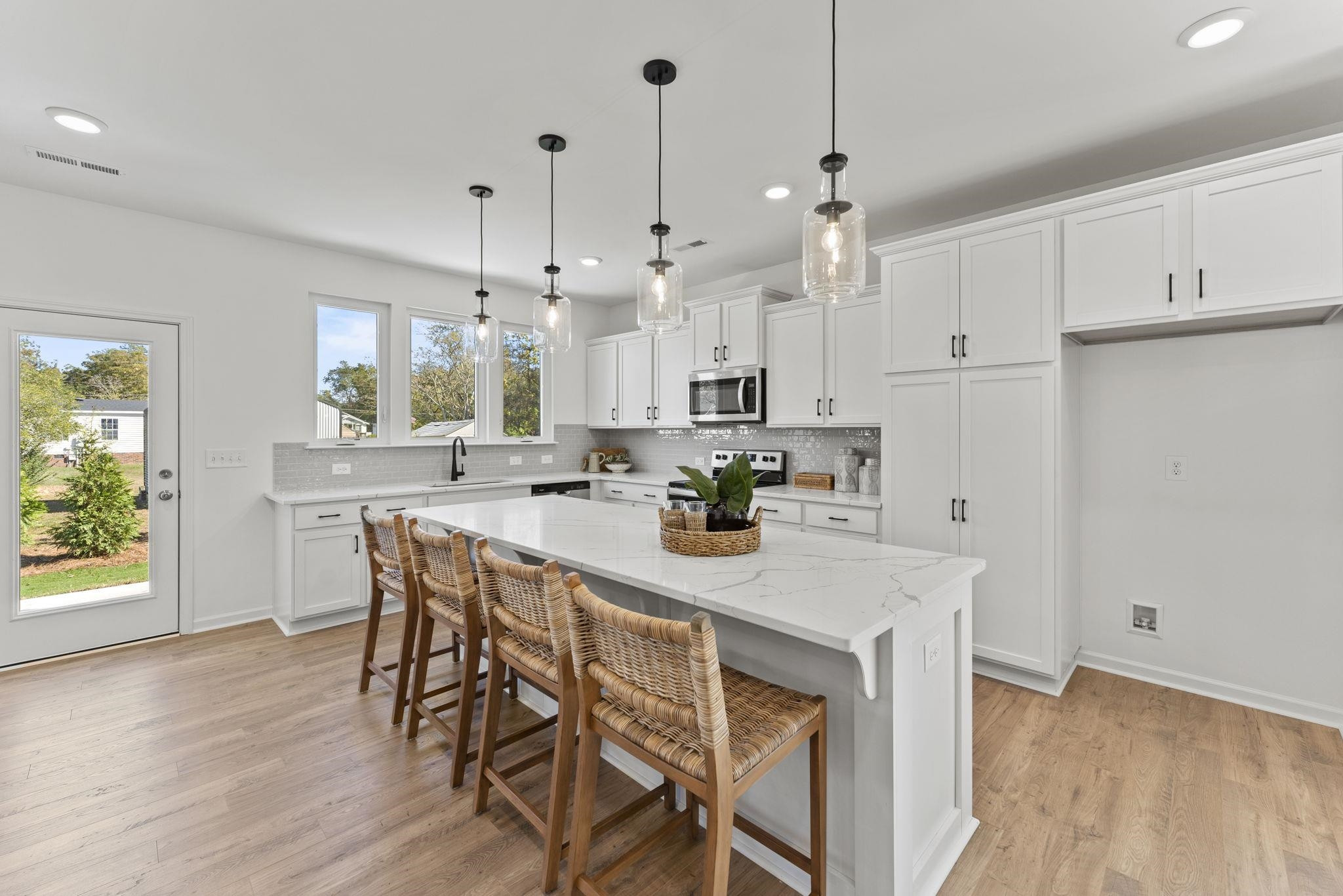 402 Cliff Court, Unit 9 Benson, NC 27504 - Photo 3 of 25 a kitchen with kitchen island a stove a table and chairs in it