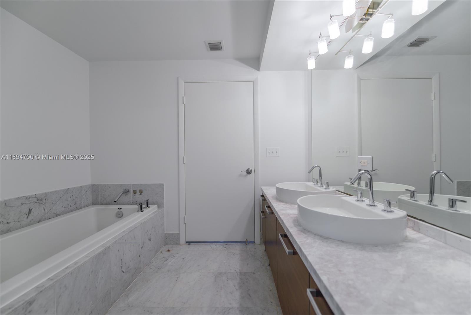 253 Northeast 2nd Street, Unit 3902 Miami, FL 33132 - Photo 17 of 47 a spacious bathroom with a bathtub sink and mirror