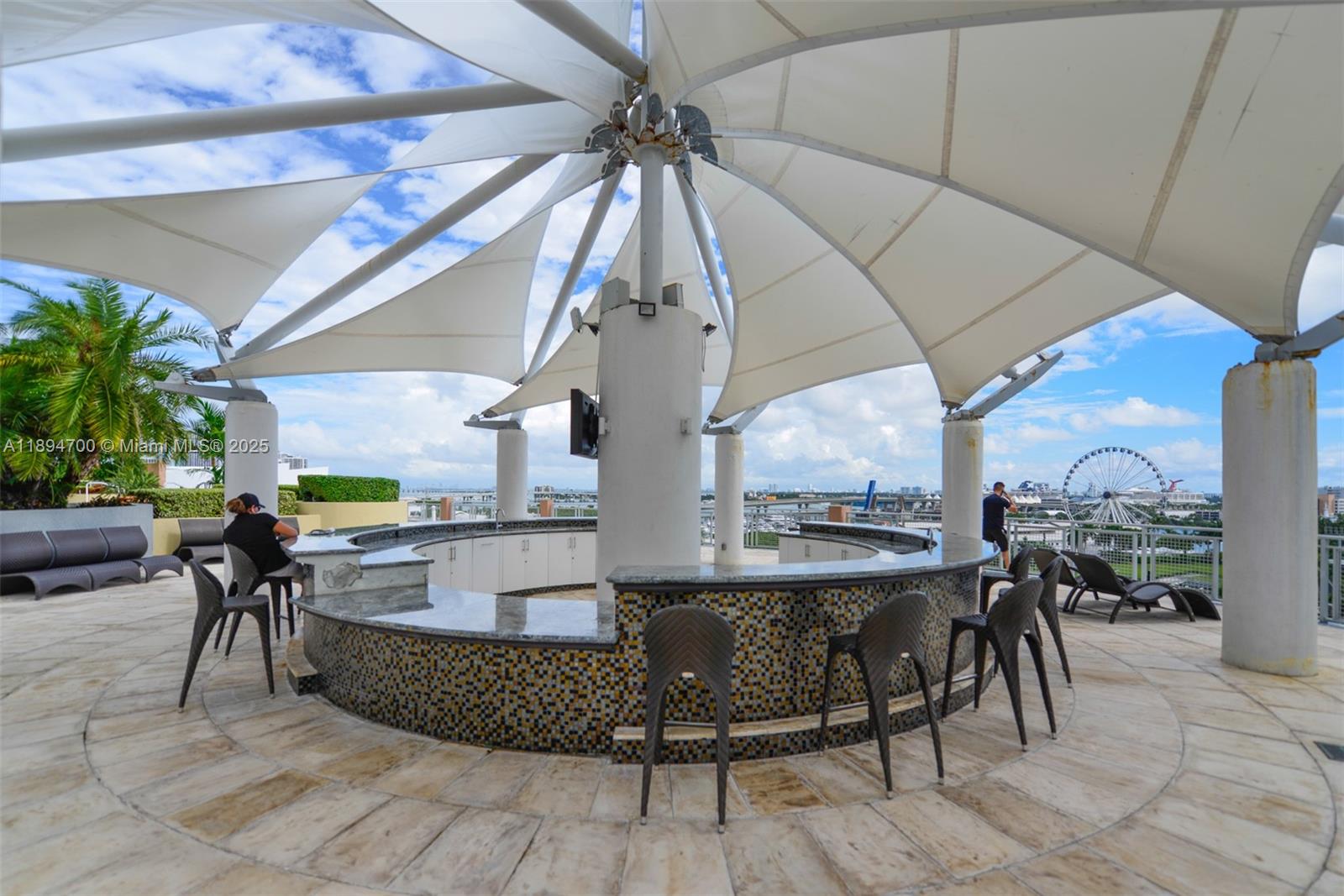 253 Northeast 2nd Street, Unit 3902 Miami, FL 33132 - Photo 29 of 47 a view of a patio with dining table and chairs under an umbrella