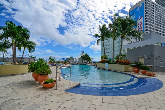 a view of a swimming pool with couches and potted plants