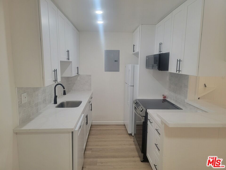4244 East 5th Street Long Beach, CA 90814 - Photo 8 of 10 a view of a kitchen with sink dishwasher and wooden floor