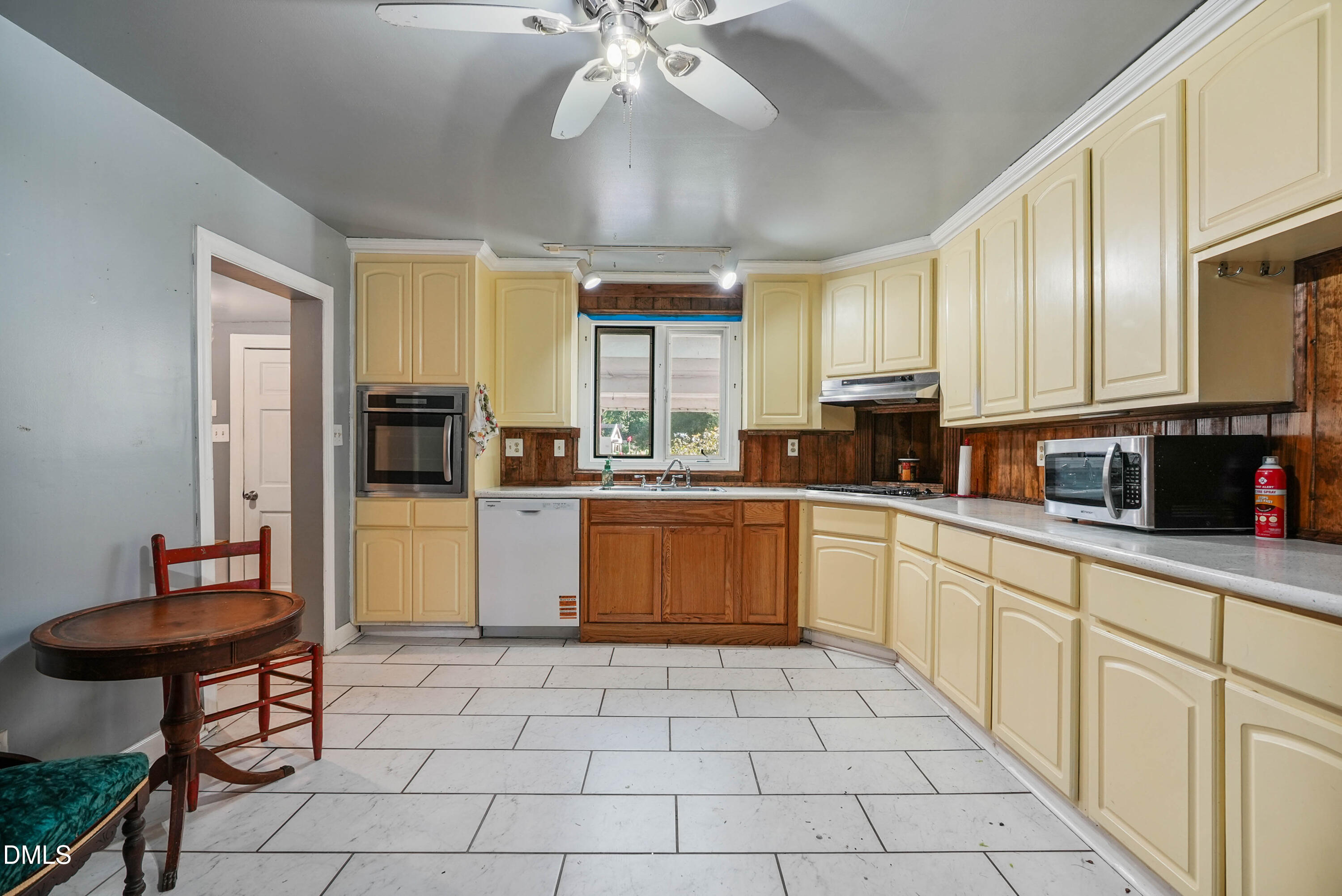 7406 Old Beulah Road Kenly, NC 27542 - Photo 8 of 30 Expansive kitchen featuring cream-colored cabinetry, white tile flooring, stainless steel wall oven, and a double basin sink