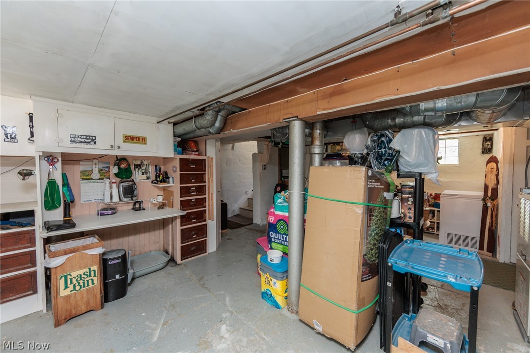 5364 Summit Road Lyndhurst, OH 44124 - Photo 29 of 42 Basement utility space featuring a built-in workbench with cabinetry and drawers, exposed ceiling joists, and concrete flooring