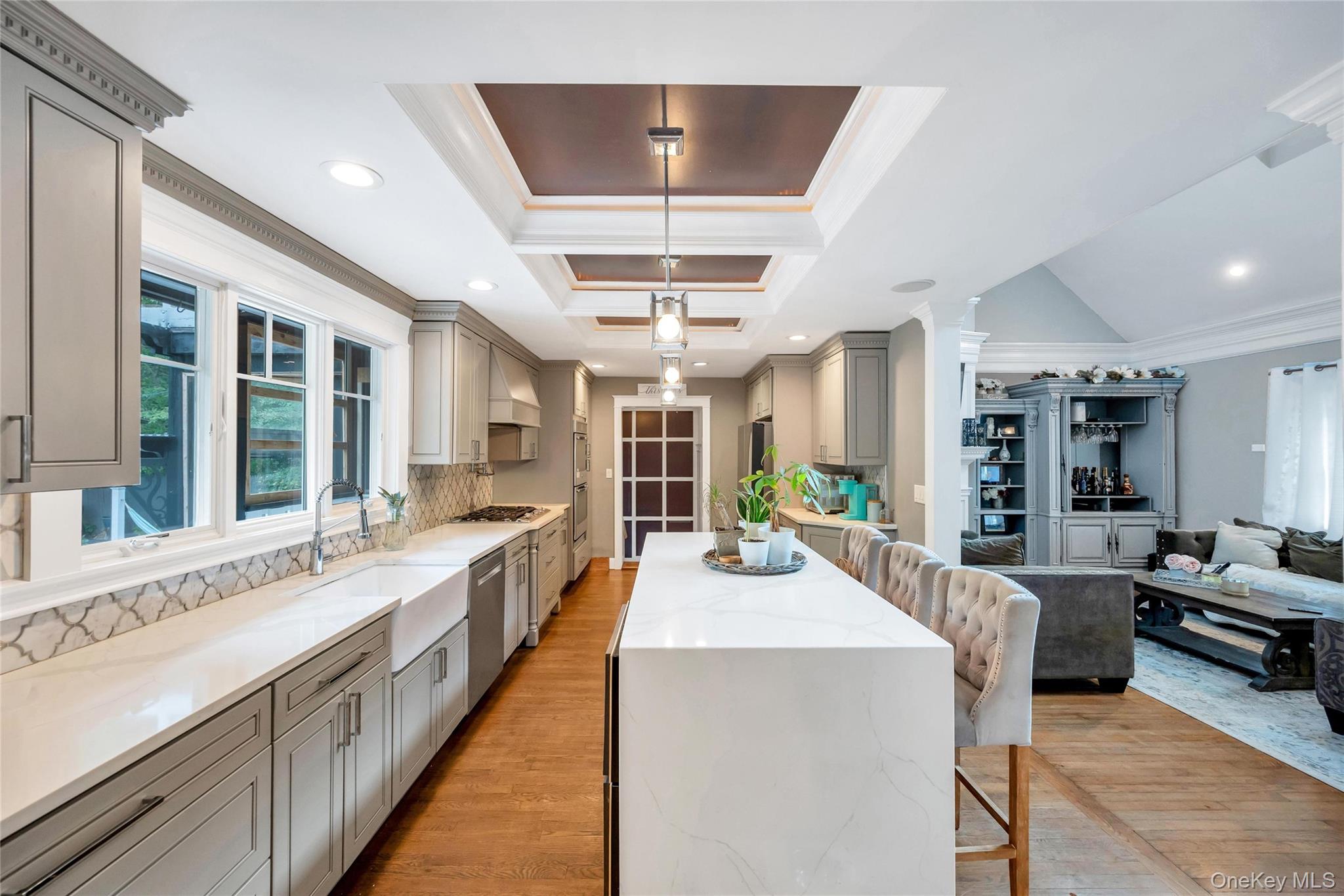 19 Joan Road Bay Shore, NY 11706 - Photo 10 of 50 Spacious kitchen featuring an expansive island with seating, a farmhouse sink, stainless steel appliances, and gray cabinetry