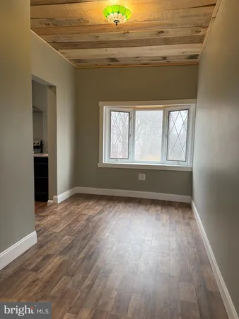 en empty room with wooden floor and windows