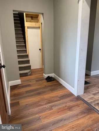 a view of a livingroom with wooden floor and stairs