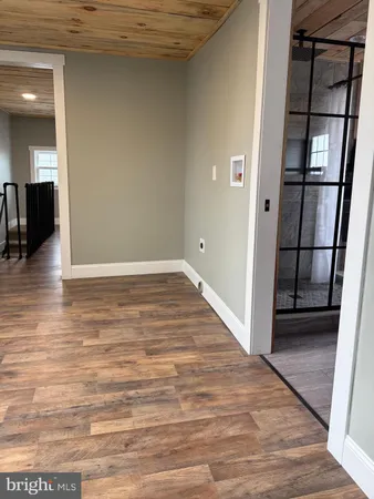 an empty room with wooden floor and entrance