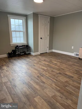 a view of a room with wooden floor and a window