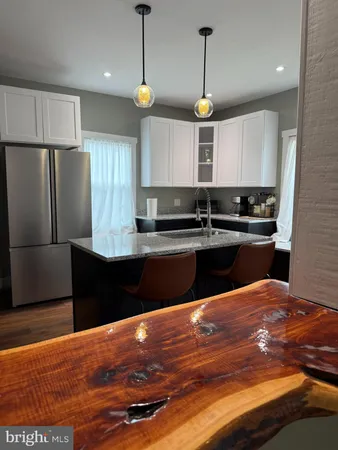 a kitchen with stainless steel appliances granite countertop a sink a stove a refrigerator and island