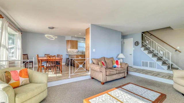 a living room with furniture and a dining table