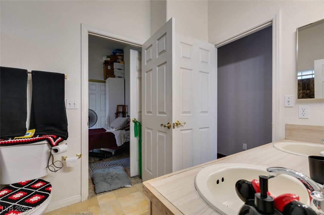 1860 Racine Drive Las Vegas, NV 89156 - Photo 12 of 36 Ensuite bathroom featuring double vanity and baseboards