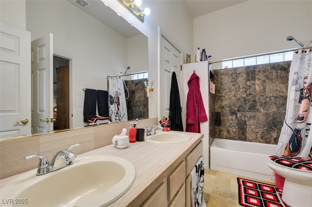 1860 Racine Drive Las Vegas, NV 89156 - Photo 14 of 36 Full bathroom with shower / tub combo with curtain, double vanity, and plenty of natural light