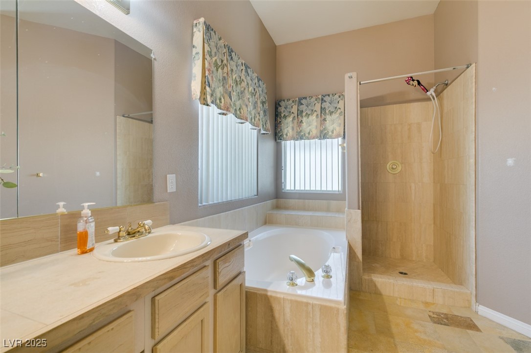 1860 Racine Drive Las Vegas, NV 89156 - Photo 17 of 36 Full bath featuring vanity, a bath, and tiled shower