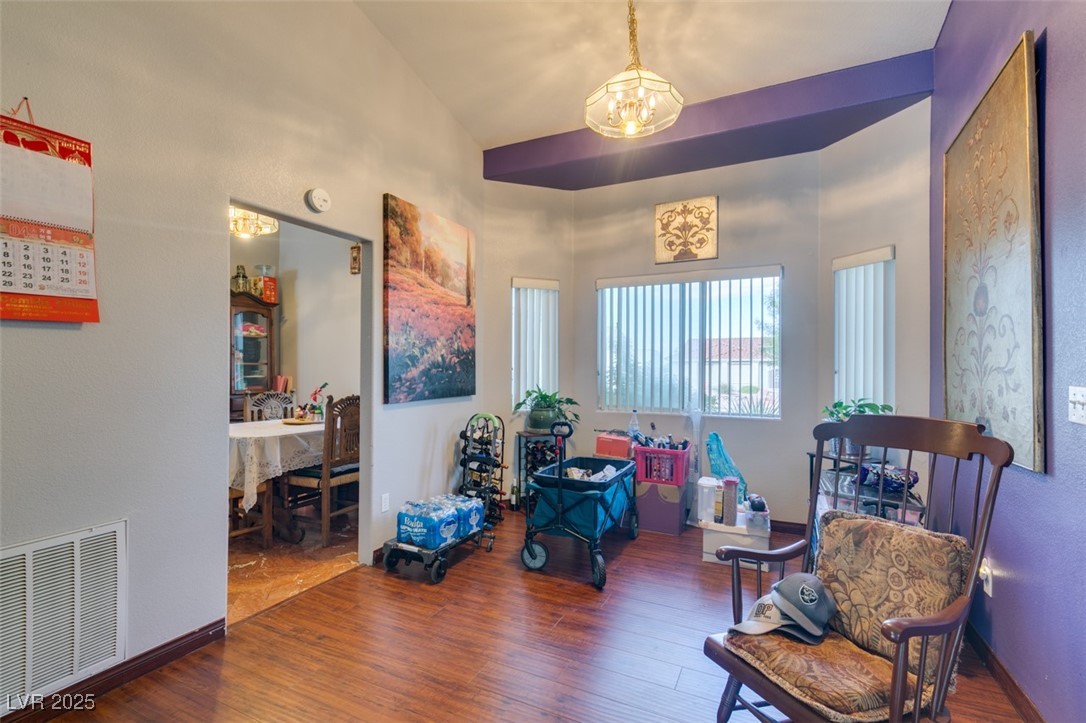 1860 Racine Drive Las Vegas, NV 89156 - Photo 29 of 36 Living area featuring wood finished floors, a chandelier, vaulted ceiling, and a textured wall