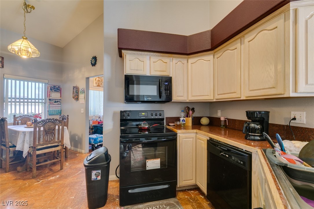 1860 Racine Drive Las Vegas, NV 89156 - Photo 6 of 36 Kitchen featuring black appliances, hanging light fixtures, high vaulted ceiling, and light countertops