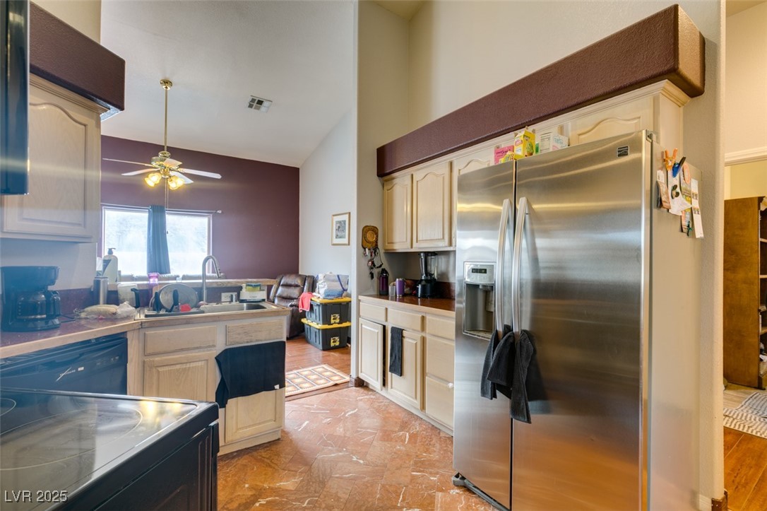 1860 Racine Drive Las Vegas, NV 89156 - Photo 10 of 36 Kitchen with stainless steel fridge, black / electric stove, vaulted ceiling, a peninsula, and ceiling fan