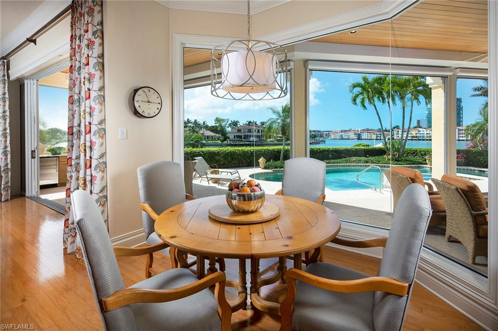 330 Neptunes Bight Naples, FL 34103 - Photo 3 of 8 a dining room with furniture a chandelier and wooden floor