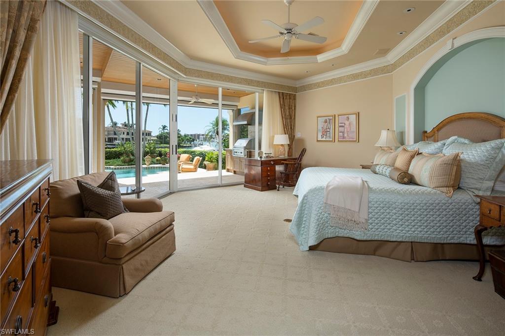 330 Neptunes Bight Naples, FL 34103 - Photo 5 of 8 a bedroom with a bed and glass walk in closet