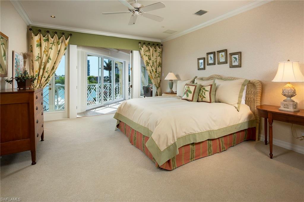 330 Neptunes Bight Naples, FL 34103 - Photo 7 of 8 a spacious bedroom with a bed lamp and a large window