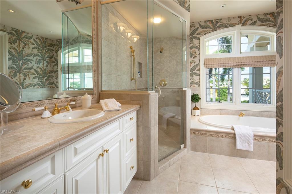 330 Neptunes Bight Naples, FL 34103 - Photo 8 of 8 a bathroom with a sink a large mirror and a bathtub