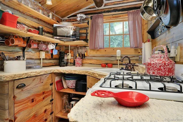 a kitchen with granite countertop lots of clutter and stainless steel appliances