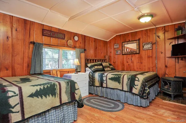 a bedroom with bed and wooden floor
