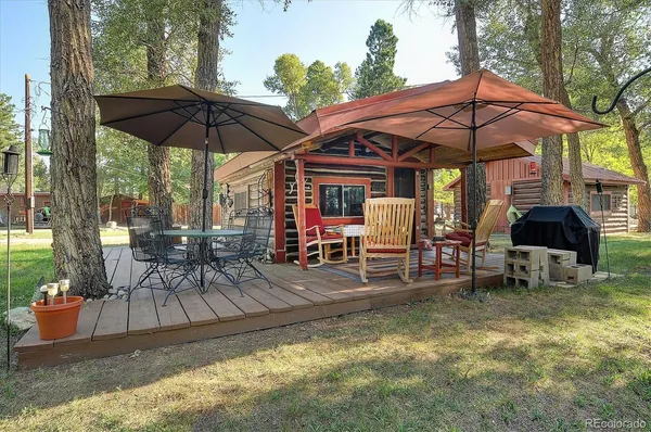 a view of patio with chairs and table under an umbrella