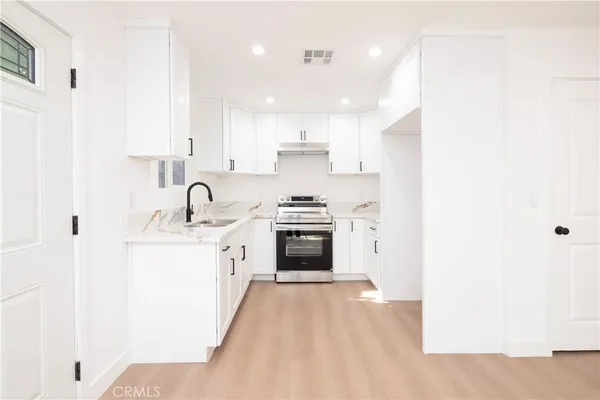 a kitchen with stainless steel appliances a stove a sink and a refrigerator