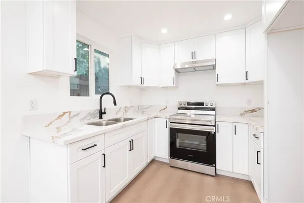 a kitchen with stainless steel appliances granite countertop a stove sink and cabinets