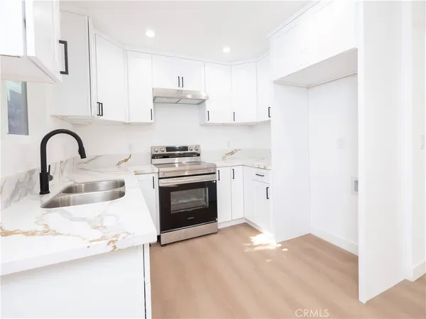 a kitchen with stainless steel appliances granite countertop a white stove top oven and sink