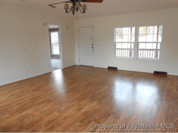 2454 Ebenezer Church Road Coats, NC 27521 - Photo 3 of 8 an empty room with wooden floor and windows