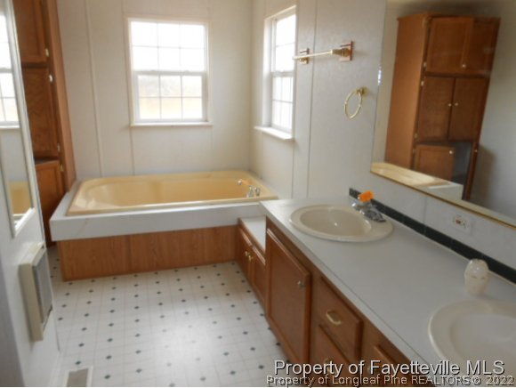2454 Ebenezer Church Road Coats, NC 27521 - Photo 8 of 8 a bathroom with a tub sink and mirror