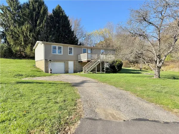 a front view of a house with a yard and trees
