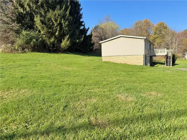 a backyard of a house with lots of green space and plants