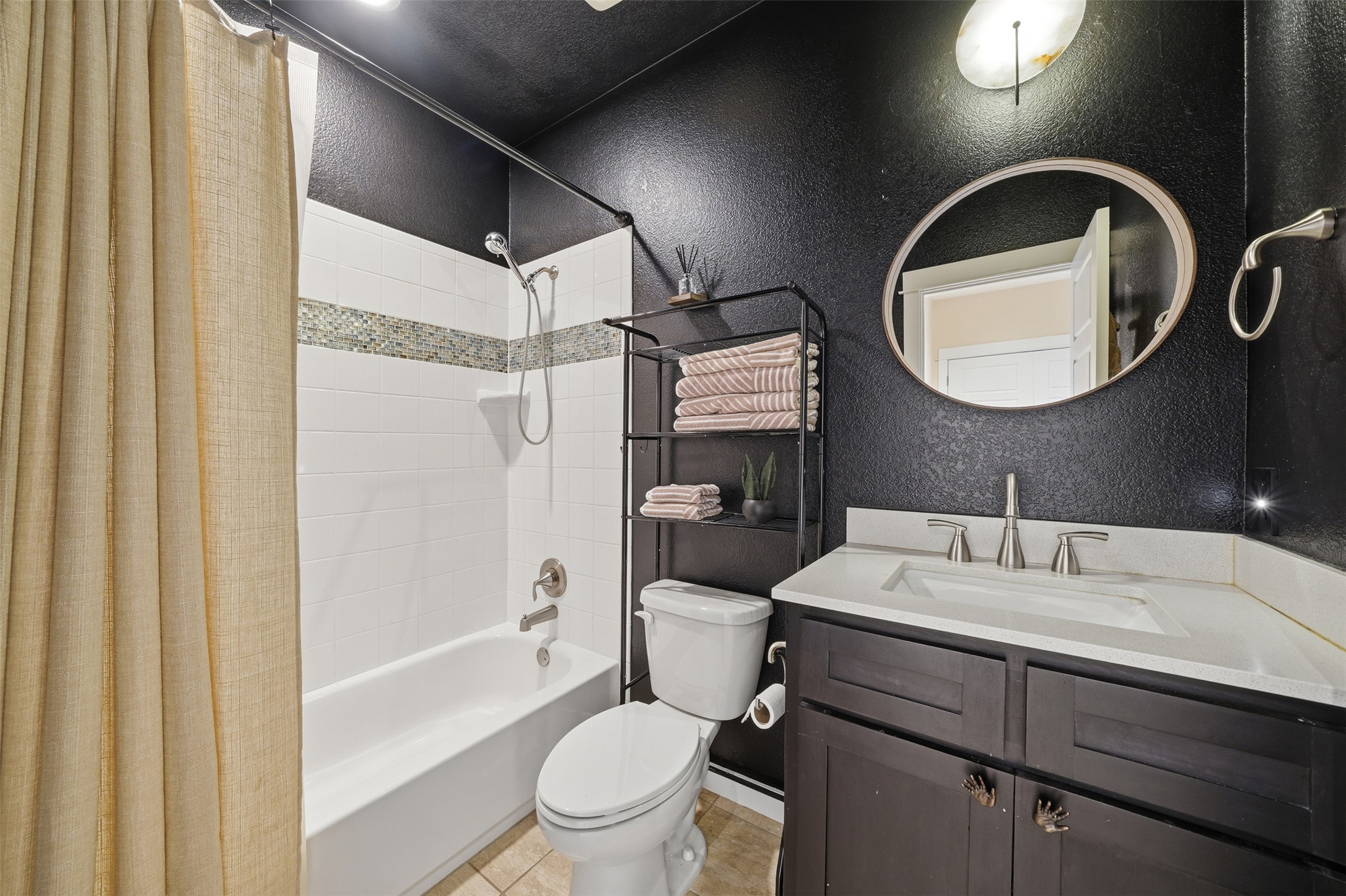 3901 Vaughan Street Austin, TX 78723 - Photo 31 of 37 Bathroom featuring a white bathtub, white subway tile surround with decorative mosaic accent, and brushed nickel fixtures