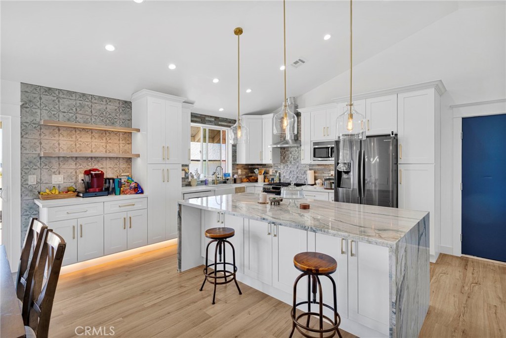 8038 Begonia Road Phelan, CA 92371 - Photo 11 of 49 a kitchen with stainless steel appliances kitchen island a refrigerator and a stove top oven