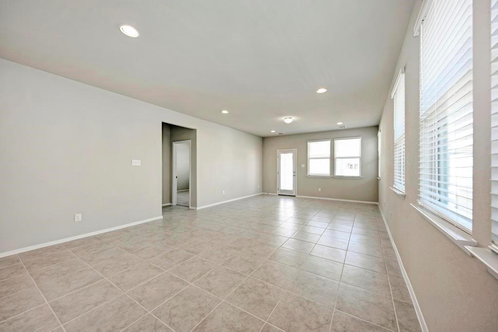 1209 Goforth Road Kyle, TX 78640 - Photo 11 of 32 A spacious, naturally illuminated room featuring durable tile flooring and recessed lighting.
