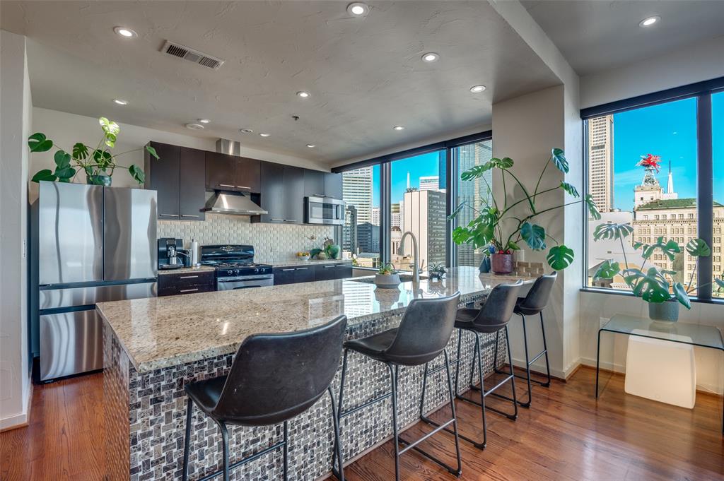 1200 Main Street, Unit 2412 Dallas, TX 75202 - Photo 11 of 36 a large kitchen with a table and chairs