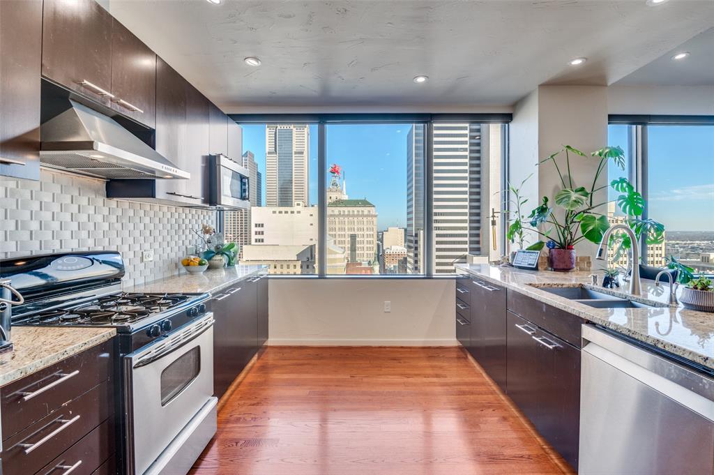 1200 Main Street, Unit 2412 Dallas, TX 75202 - Photo 13 of 36 a kitchen with stainless steel appliances granite countertop a stove a sink and a refrigerator