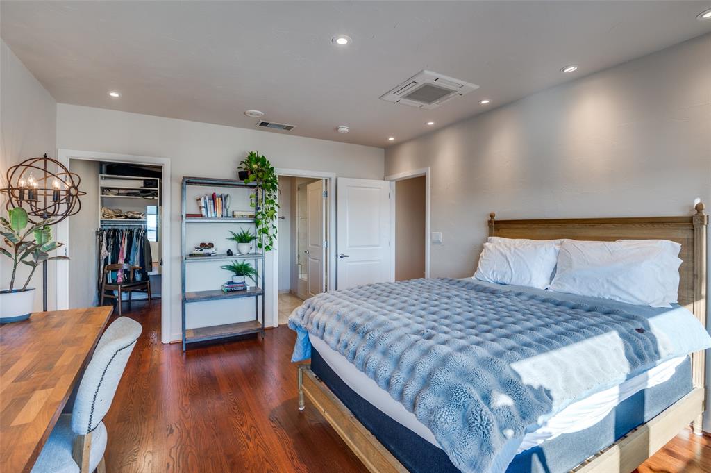 1200 Main Street, Unit 2412 Dallas, TX 75202 - Photo 19 of 36 a bedroom with a large bed and a wooden floor